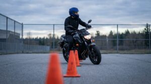 Motorleerling rijdt de langzame slalom tussen pionnen op een oefenterrein